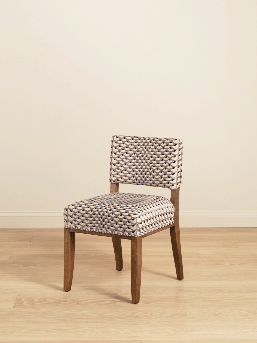 Wooden chair with patterned upholstery on a beige background. 