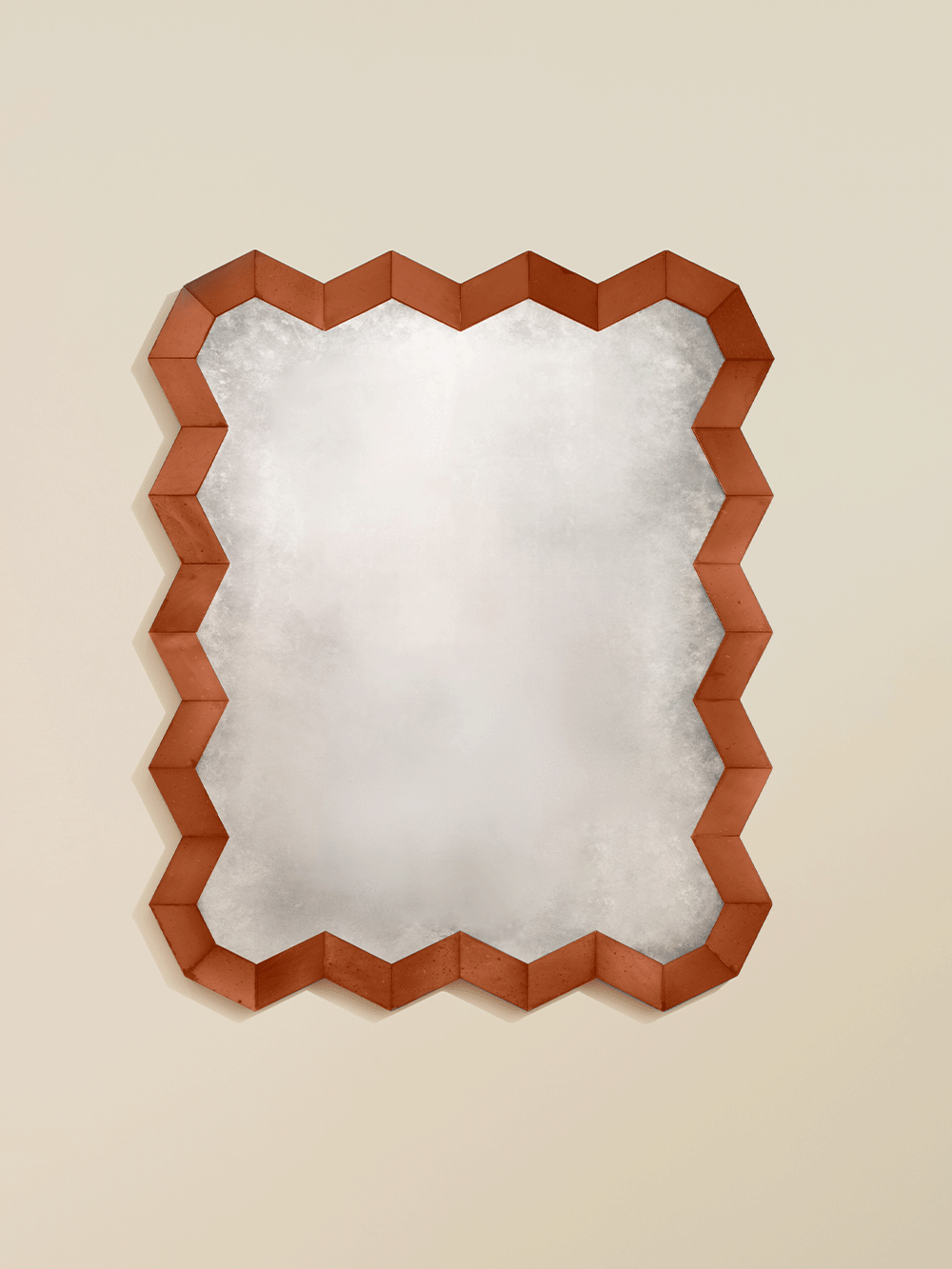 Decorative wall mirror with a geometric wooden and red glass frame on a beige background.