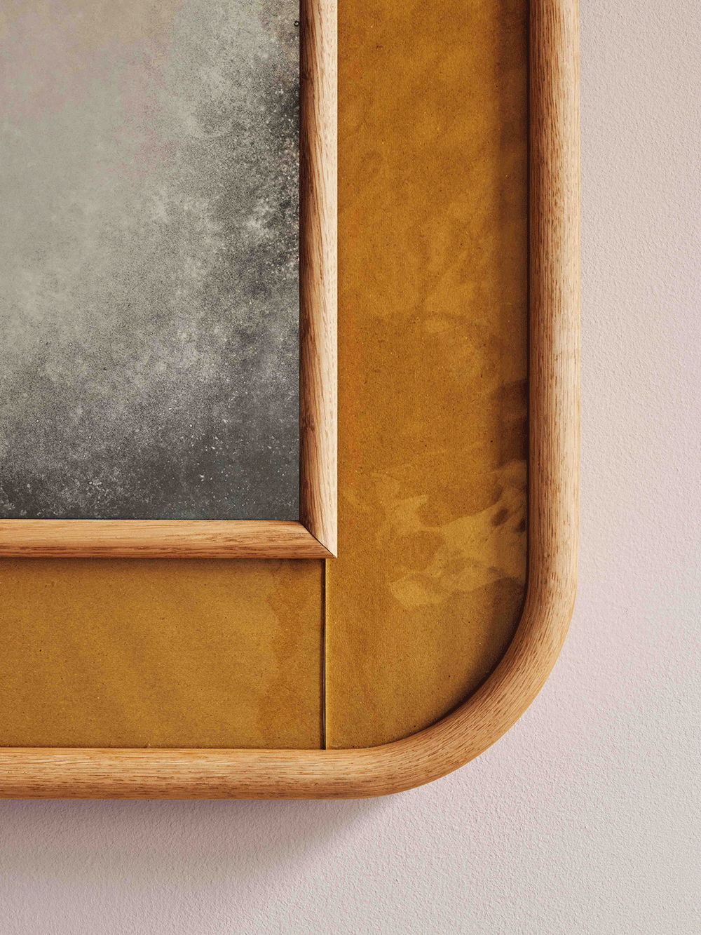 Wooden frame with gold glass on a beige background.