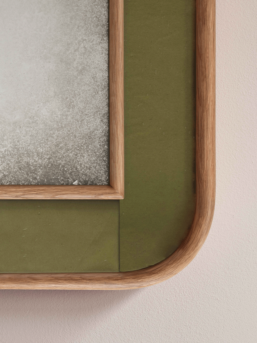 Wooden frame with green glass on a beige background.