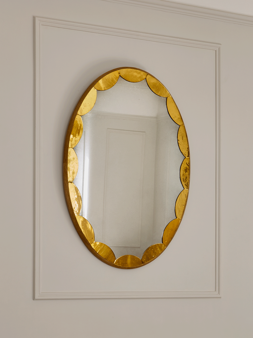 Gold-framed mirror on a white wall.