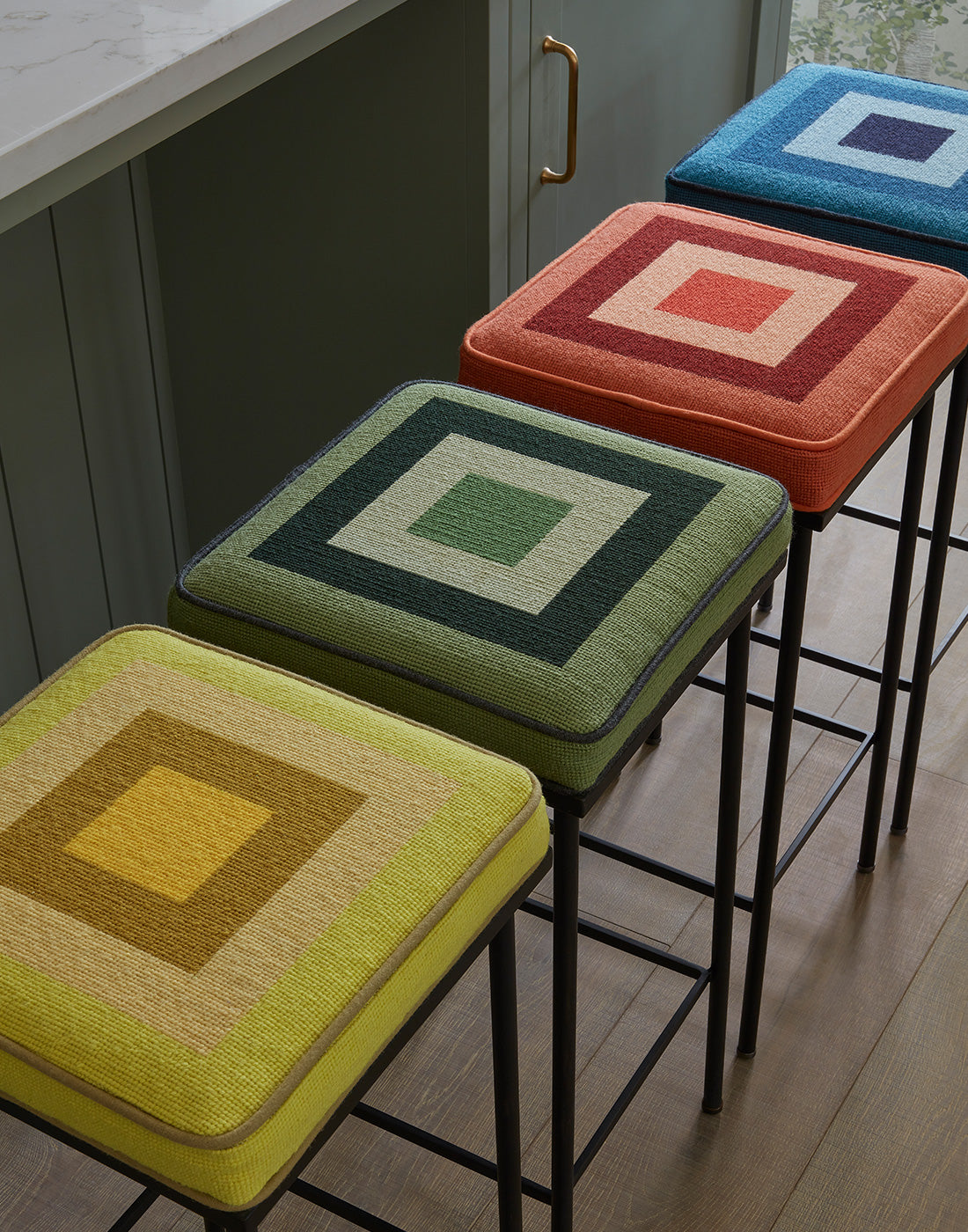 Colourful square-patterned bar stools in a kitchen setting.