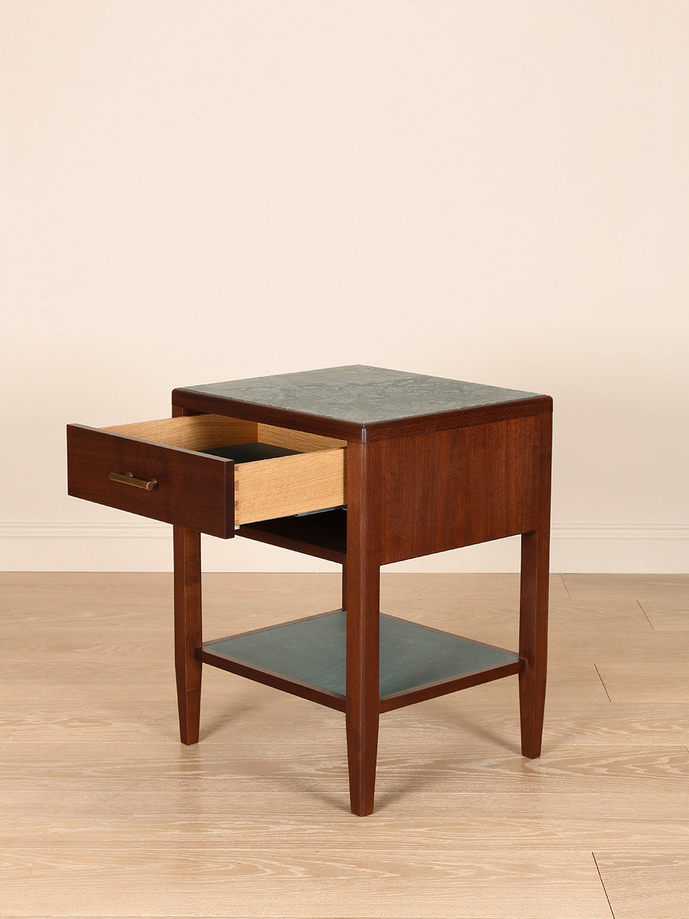 Wooden bedside table with marble top on a beige background.