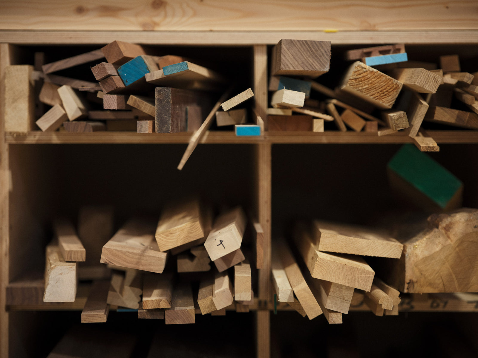 Wooden blocks and planks on a wooden shelf.