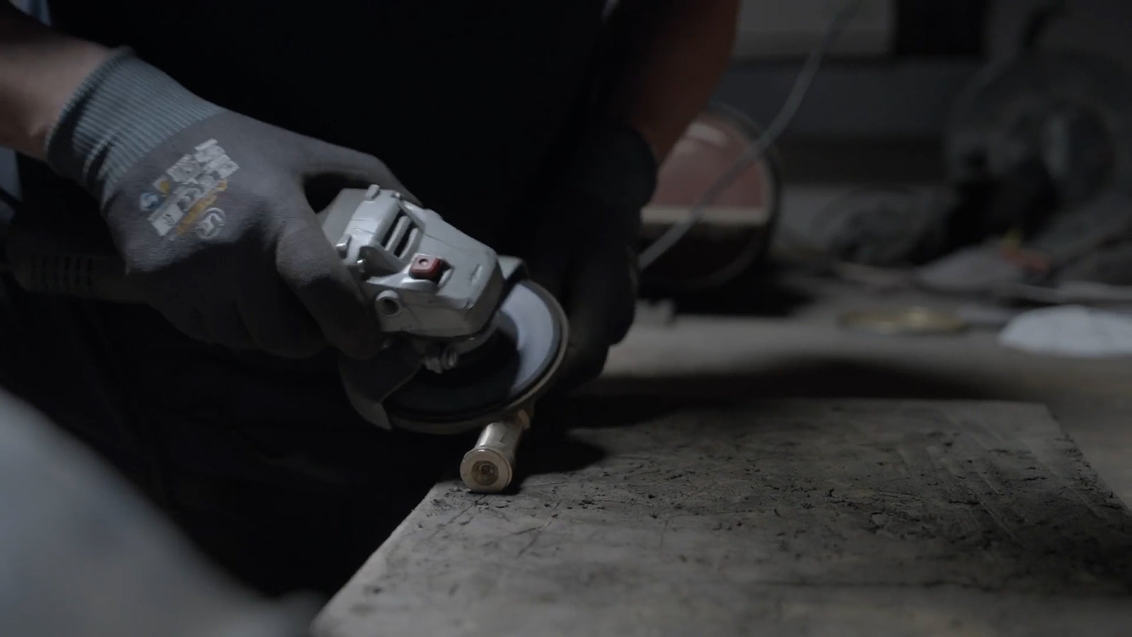 Person using a grinder on a bench.