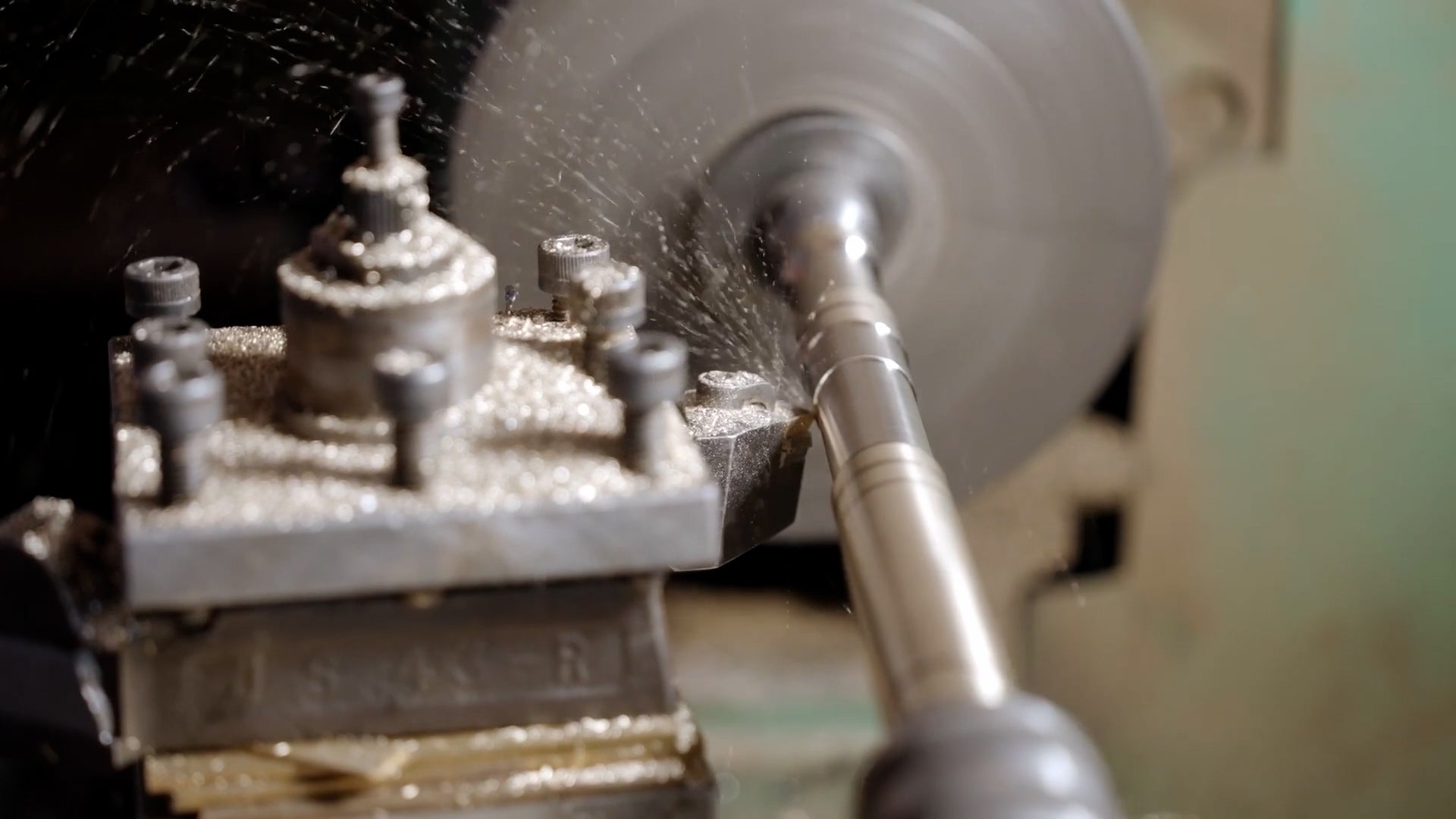 Close-up of a lathe machine in operation with metal shavings.