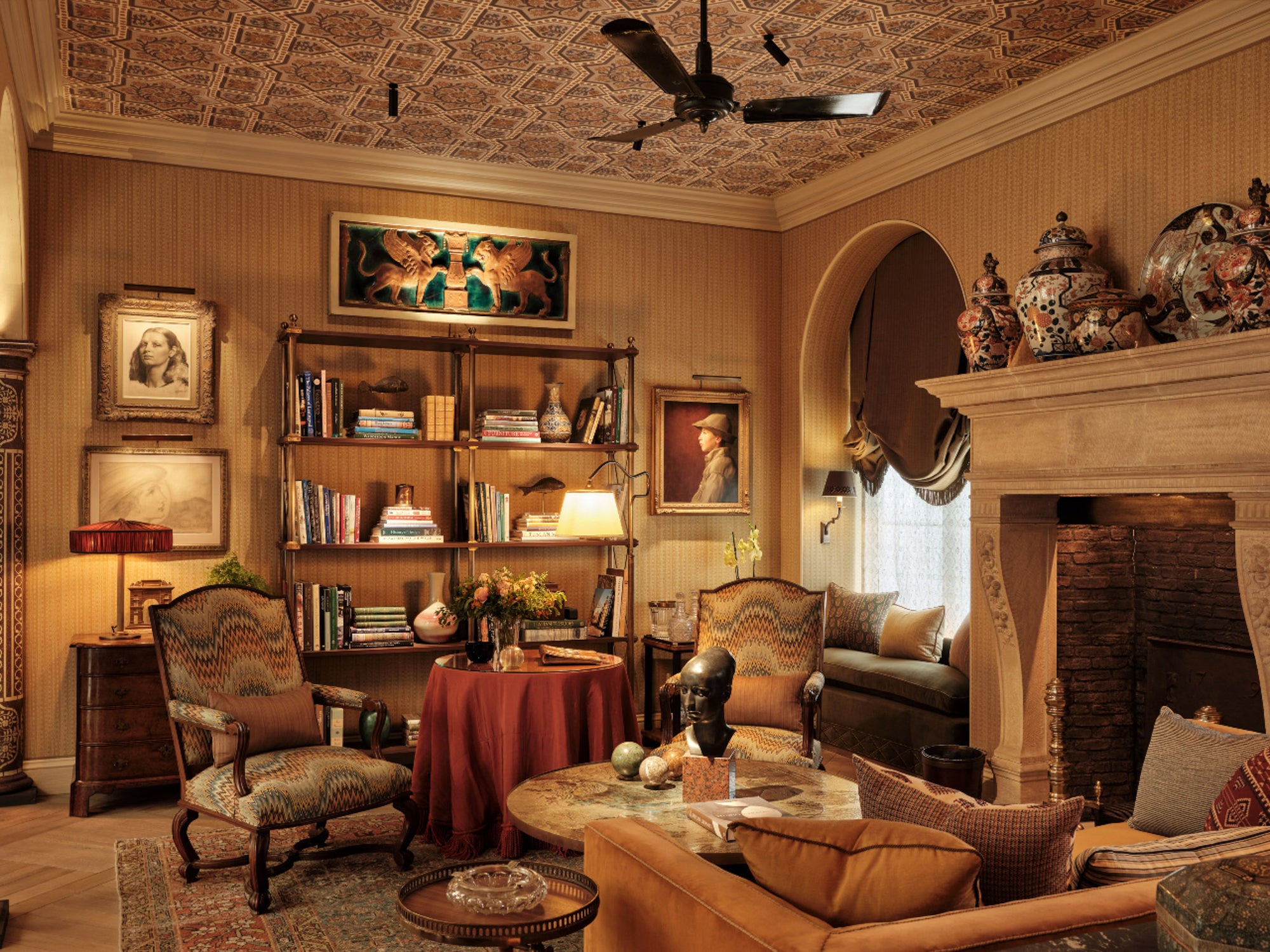Luxurious living room with ornate ceiling, fireplace, etagere and decorative furniture.