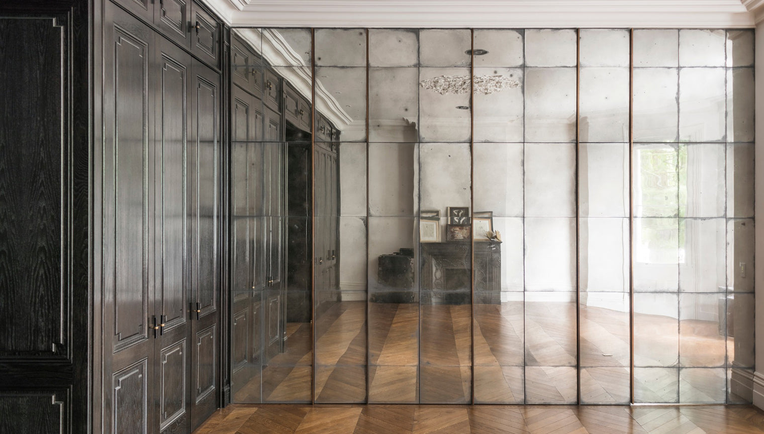 Modern interior with reflective glass walls and dark wood cabinets.