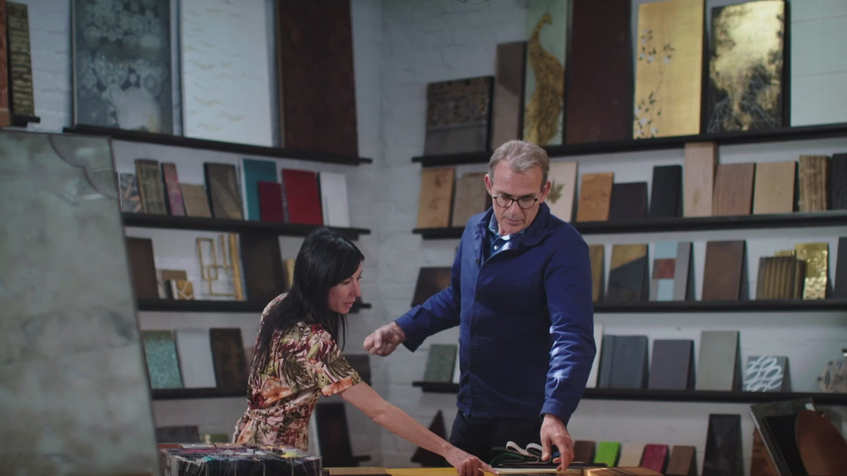 People having a discussion surrounded by material samples on shelves.