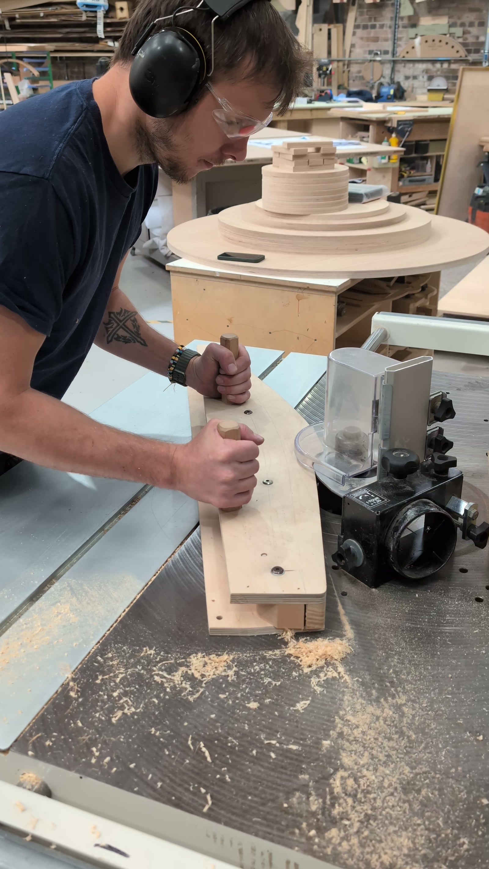 Man in wood workshop using machine.
