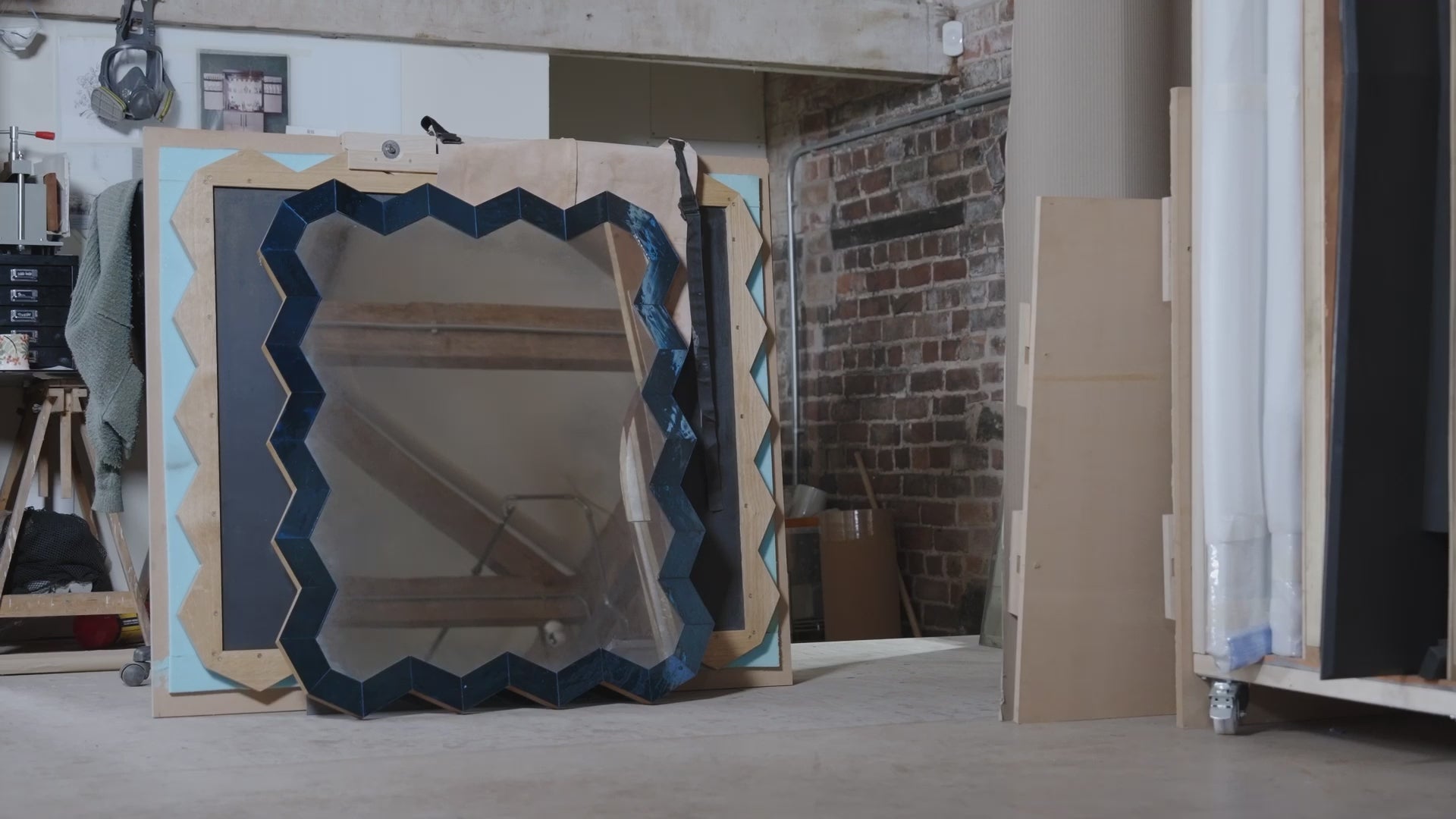 People working to make a mirror in a workshop setting. 