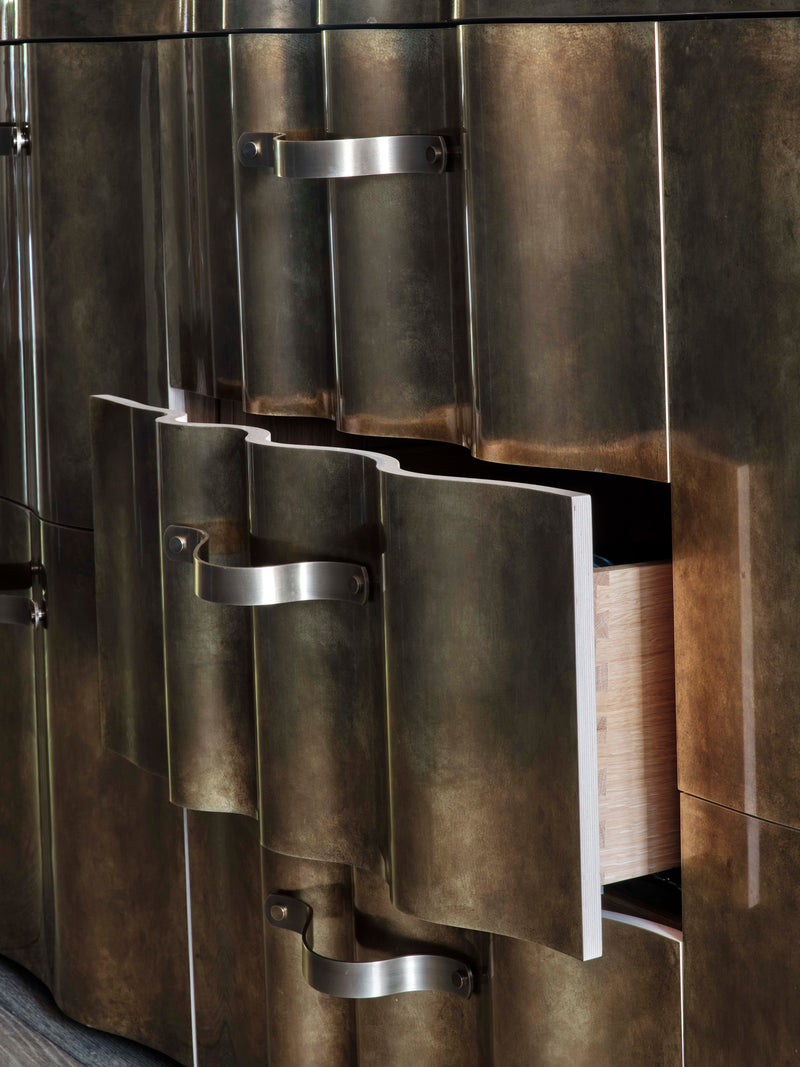 Curved brass cabinet with unique design and handles.